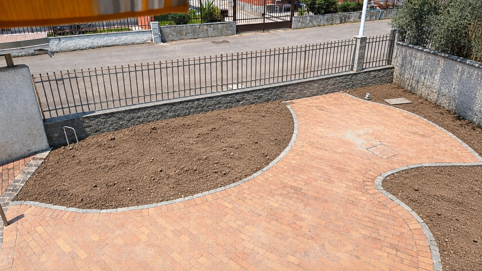 Prima: aiuole in terra lungo la pavimentazione del cortile
